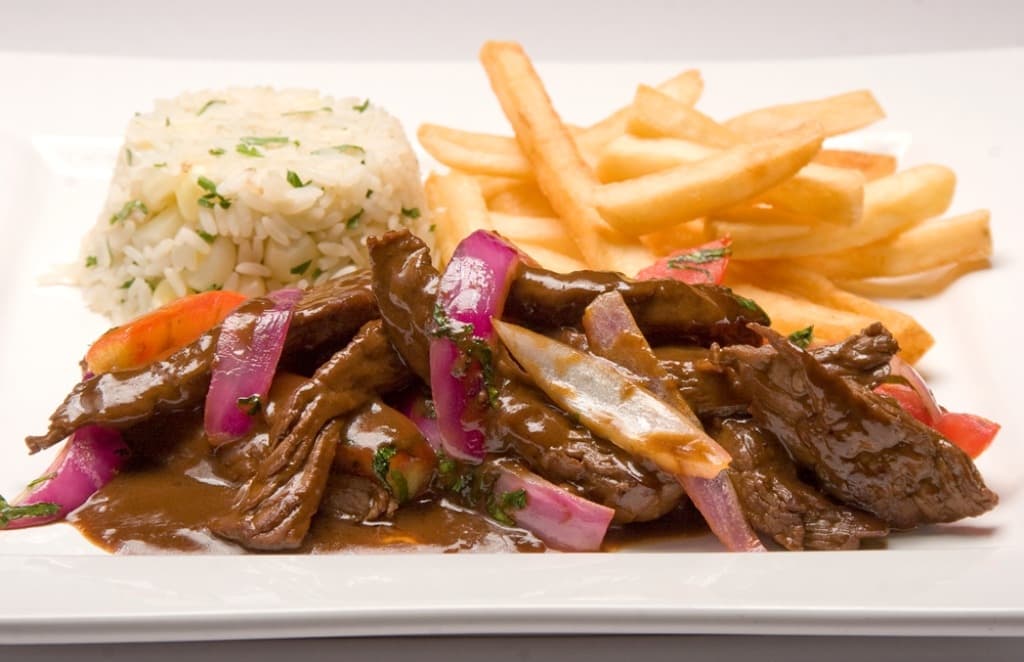 Traditional Peruvian lomo saltado with fries and rice