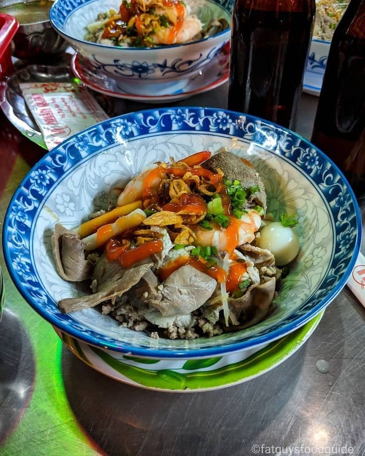 Bowl of hu tieu nam vang with shrimp, pork, quail egg, and toppings