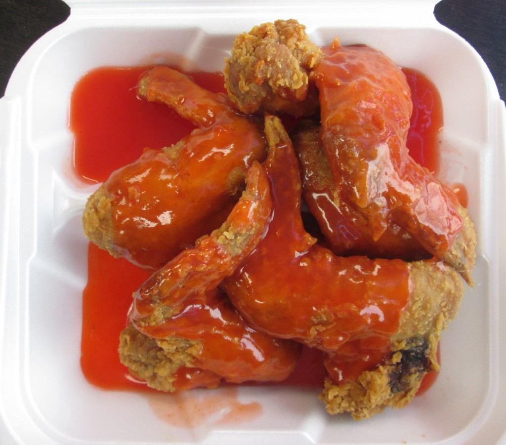 Crispy chicken wings coated in red mumbo sauce