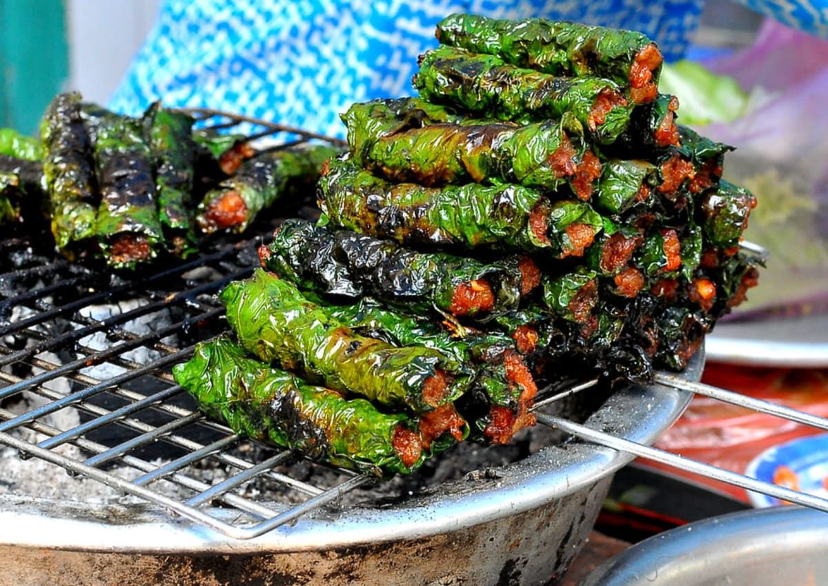 Bo la lot grilling over charcoal at a Ho Chi Minh street stall