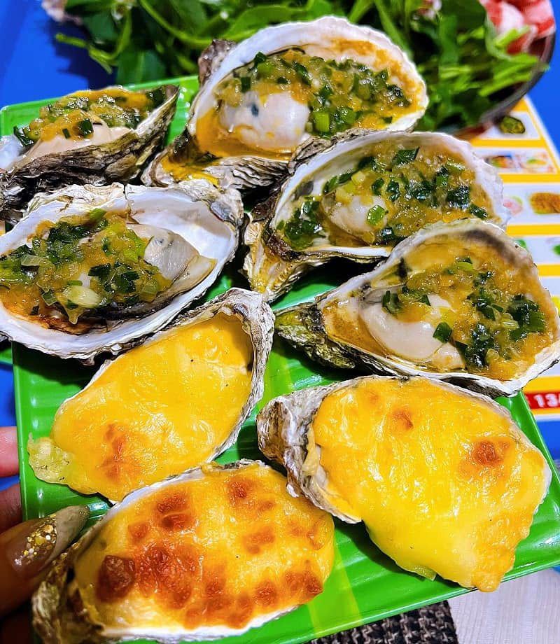 Grilled oysters topped with scallion oil and cheese at a Ho Chi Minh street stall