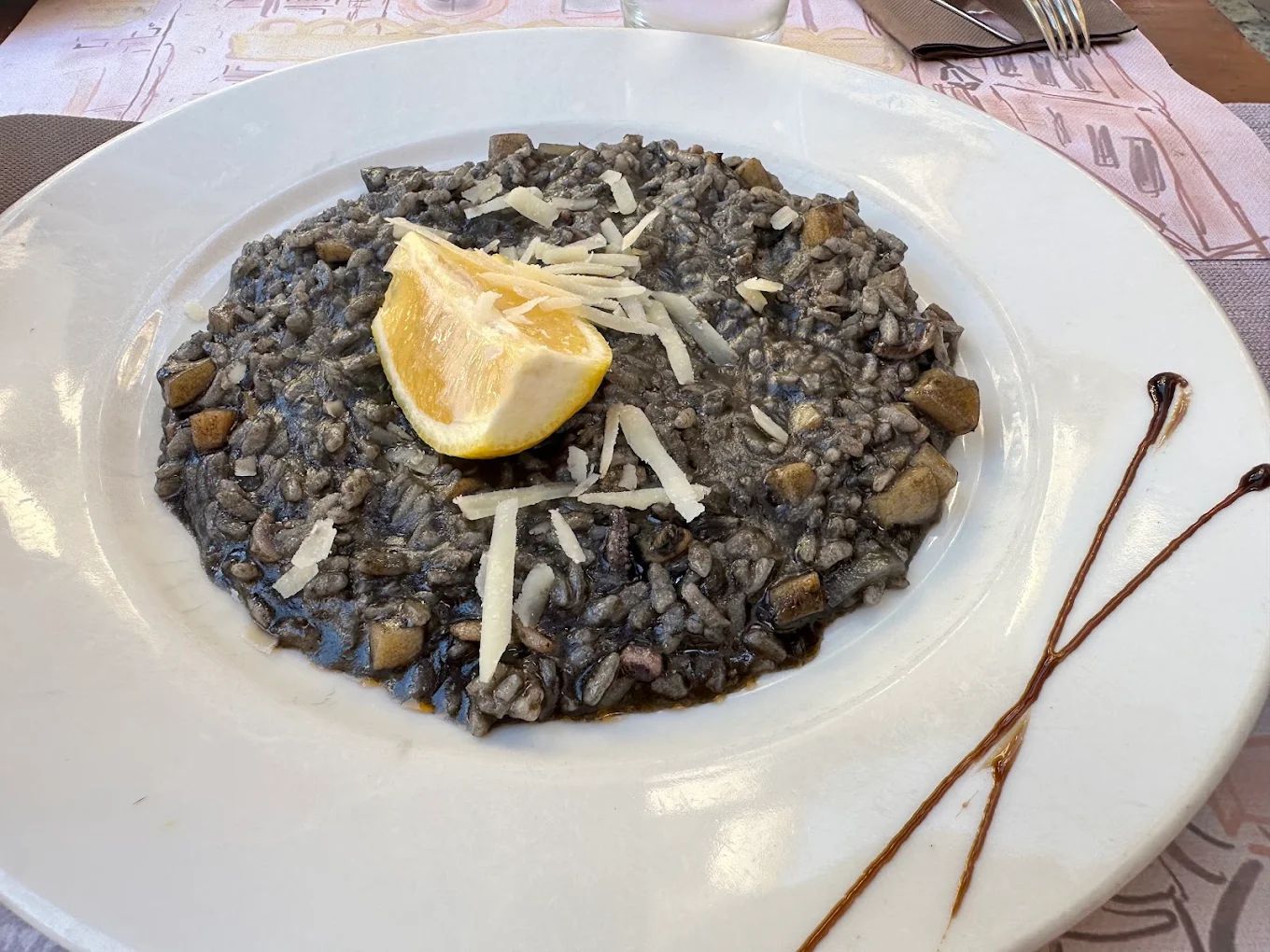 Black ink risotto served with lemon and shaved cheese in Kotor