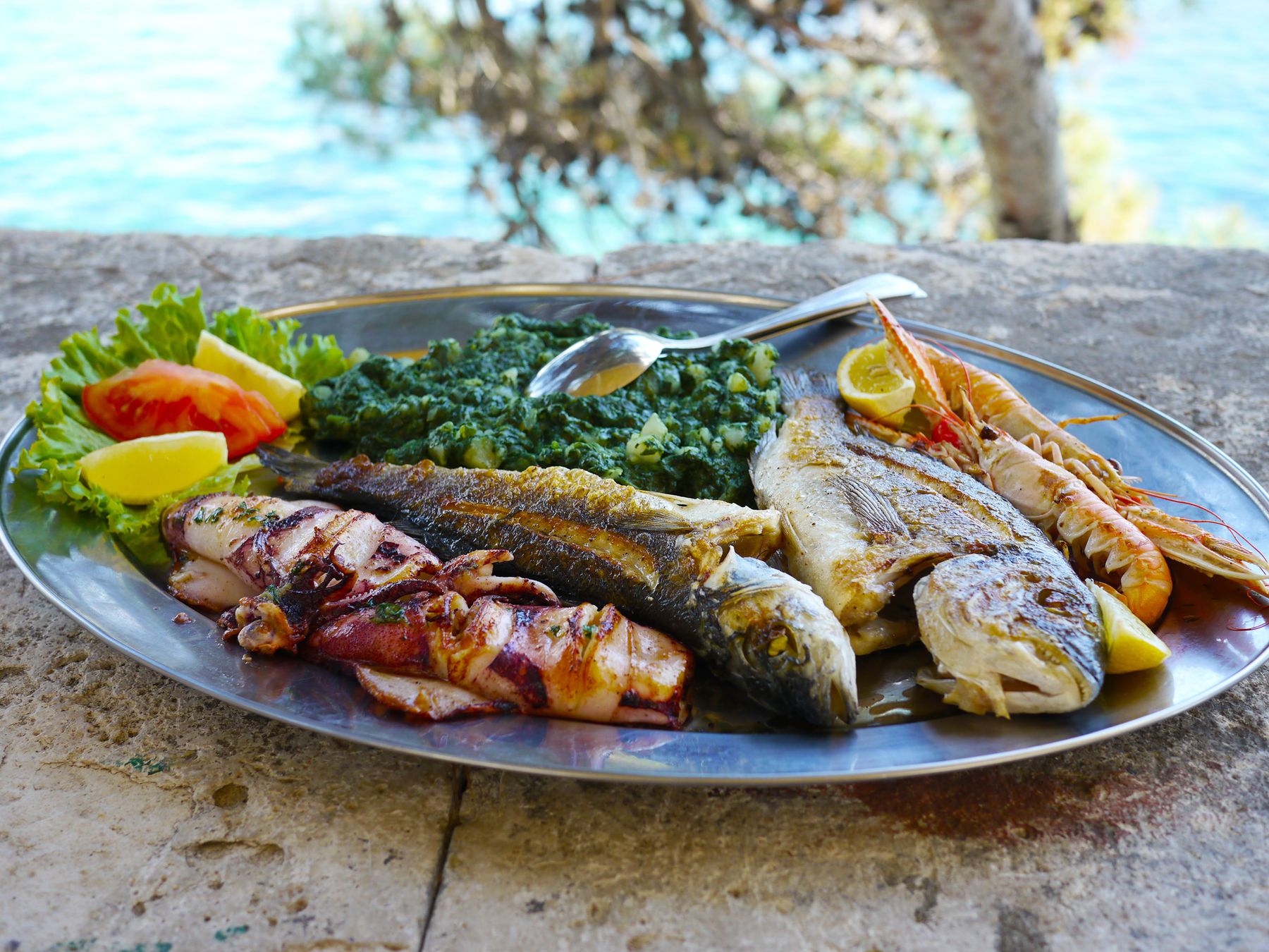 Grilled Adriatic fish and seafood platter served by the water in Kotor