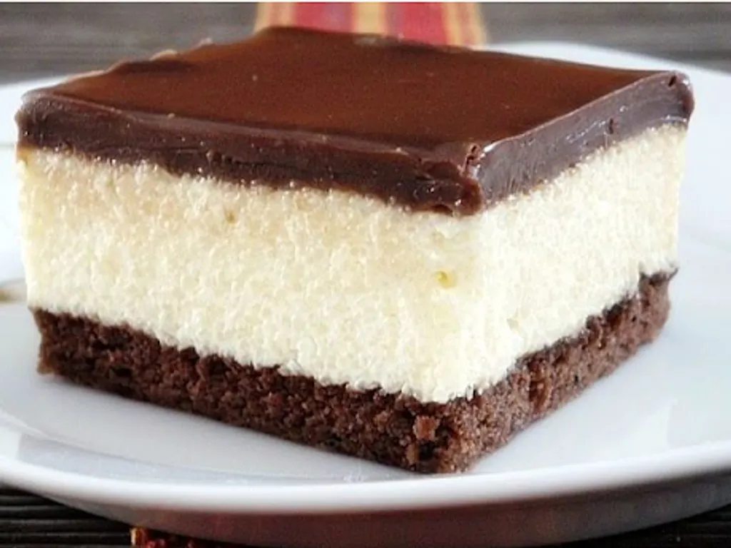 Slice of Ledena Kocka layered cream cake with a chocolate top