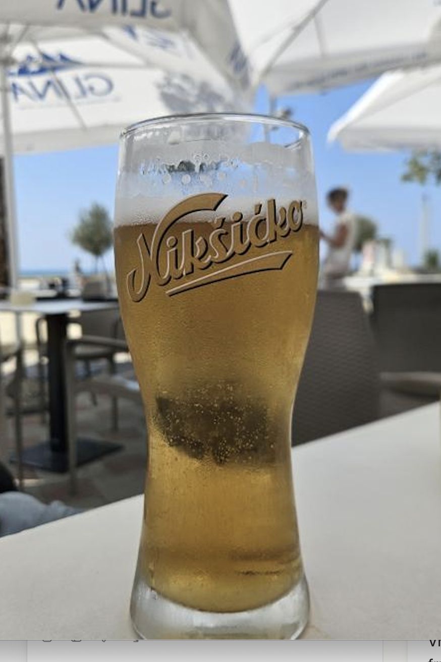Bottle and glass of Nikšićko beer overlooking the Bay of Kotor