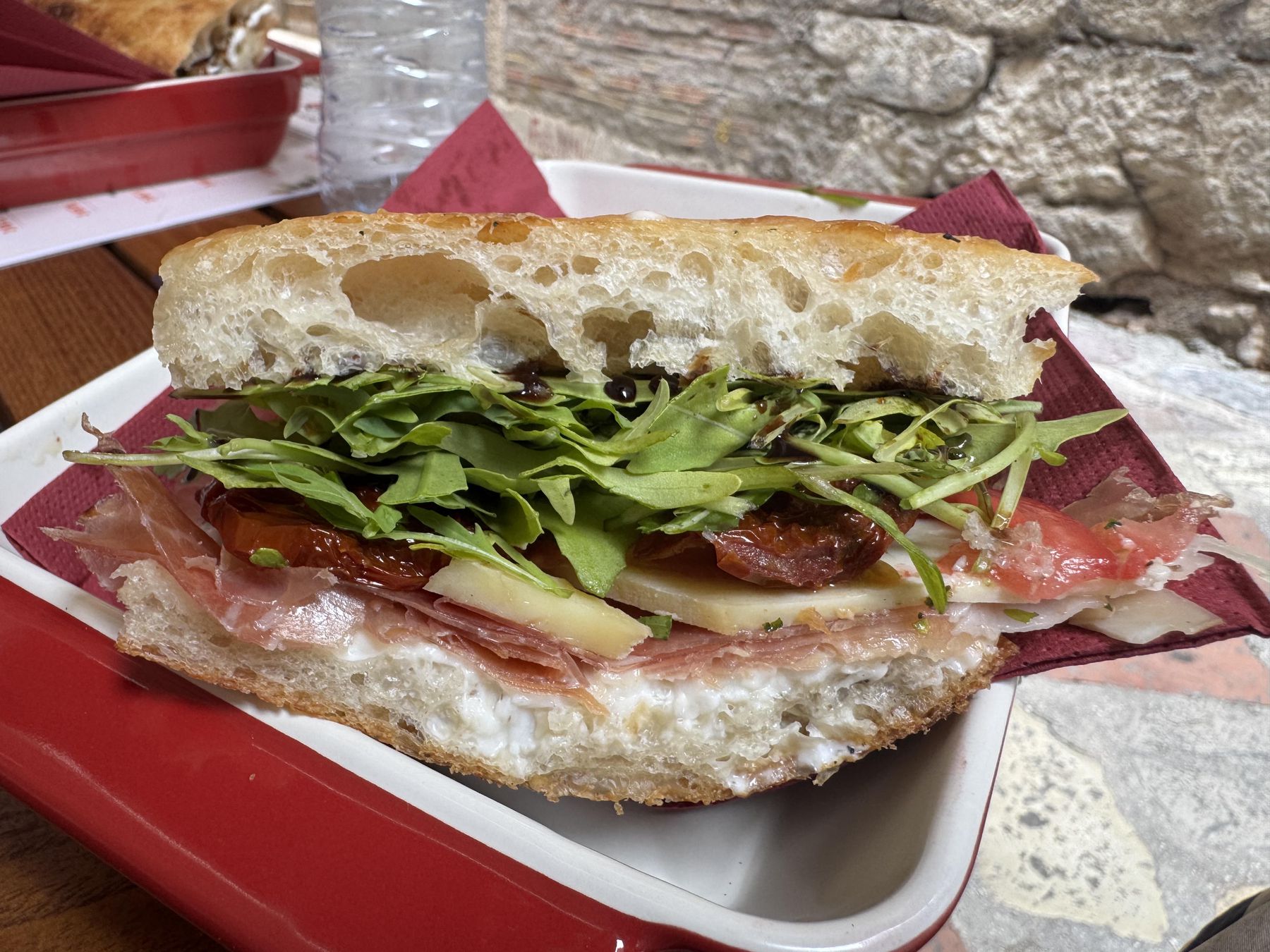 Njeguski prsut sandwich with cheese, arugula, and tomato in Kotor