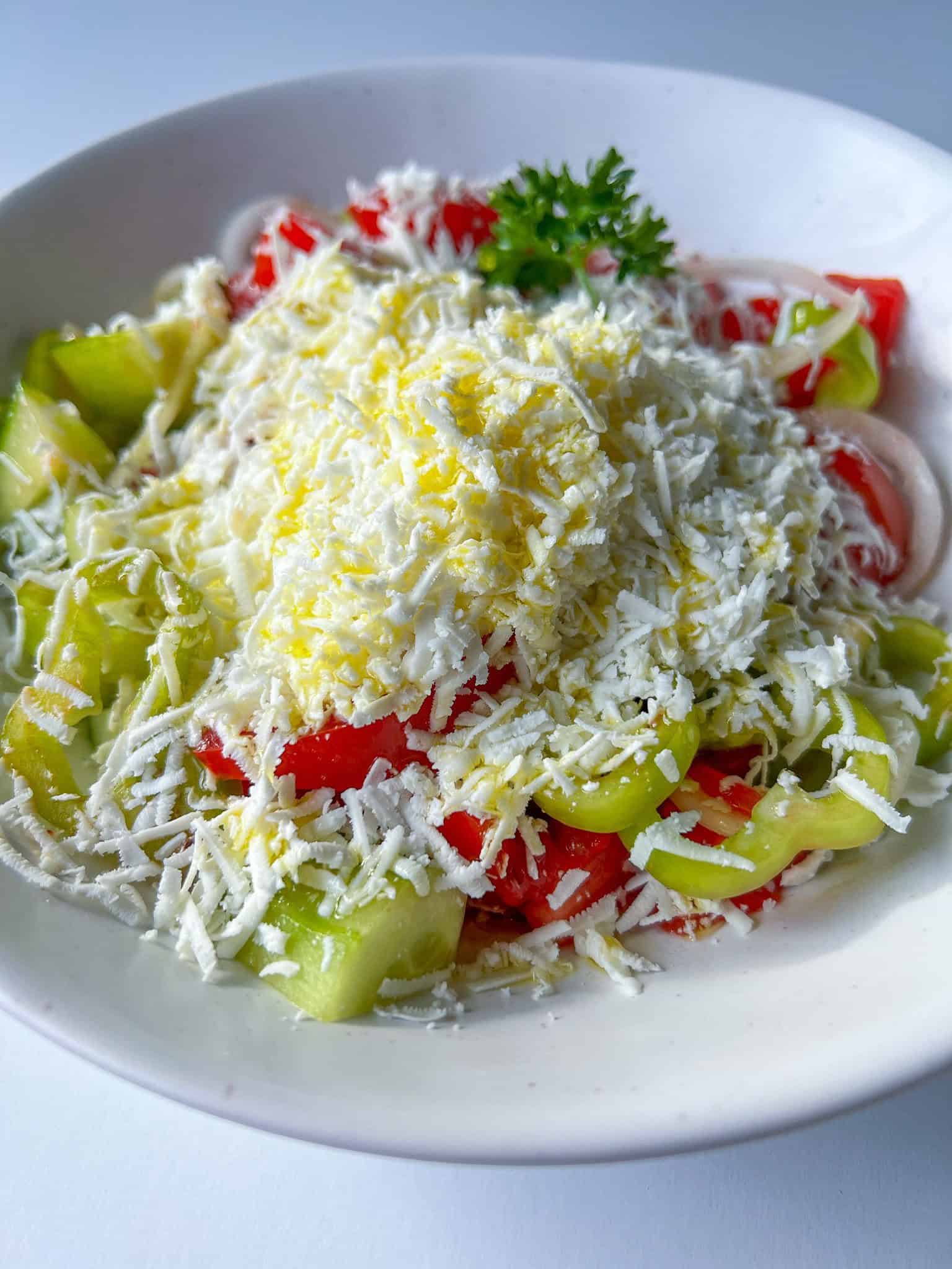 Montenegrin Sopska salad with tomatoes, cucumbers, peppers, and grated white cheese in Kotor