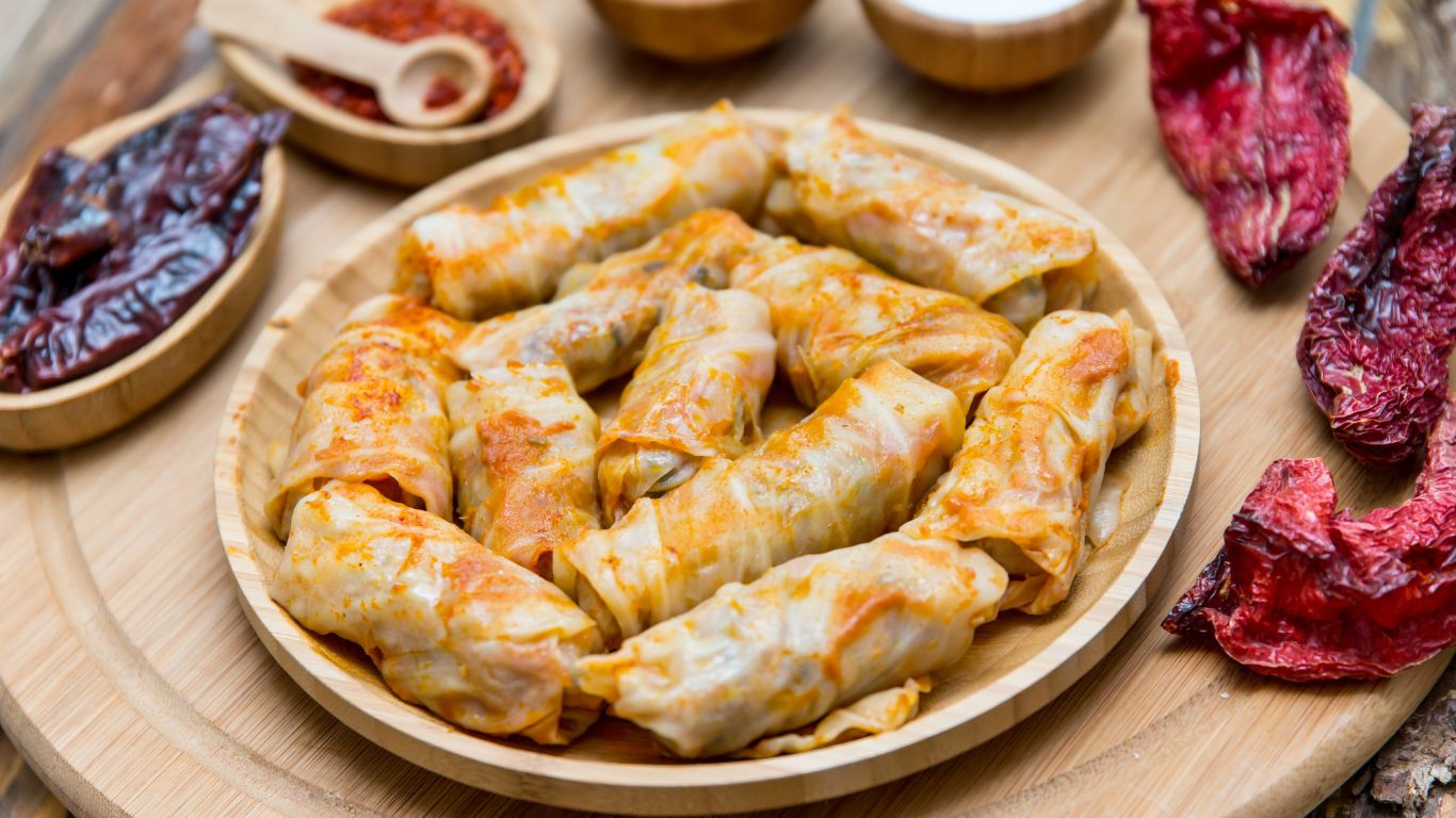 Plate of sarma cabbage rolls arranged on a wooden platter