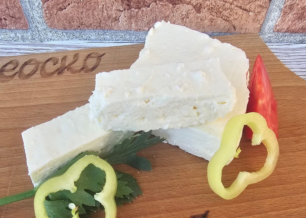 Sjenica cheese served in thick white slices on a wooden board