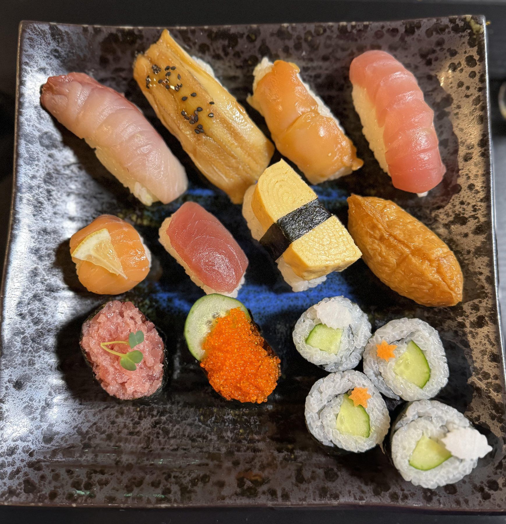 Assorted nigiri sushi on a black plate