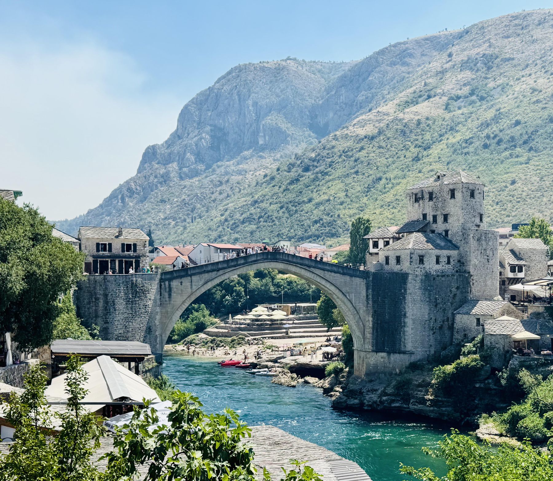 Mostar's Old Bridge spanning the Neretva River with mountains behind it